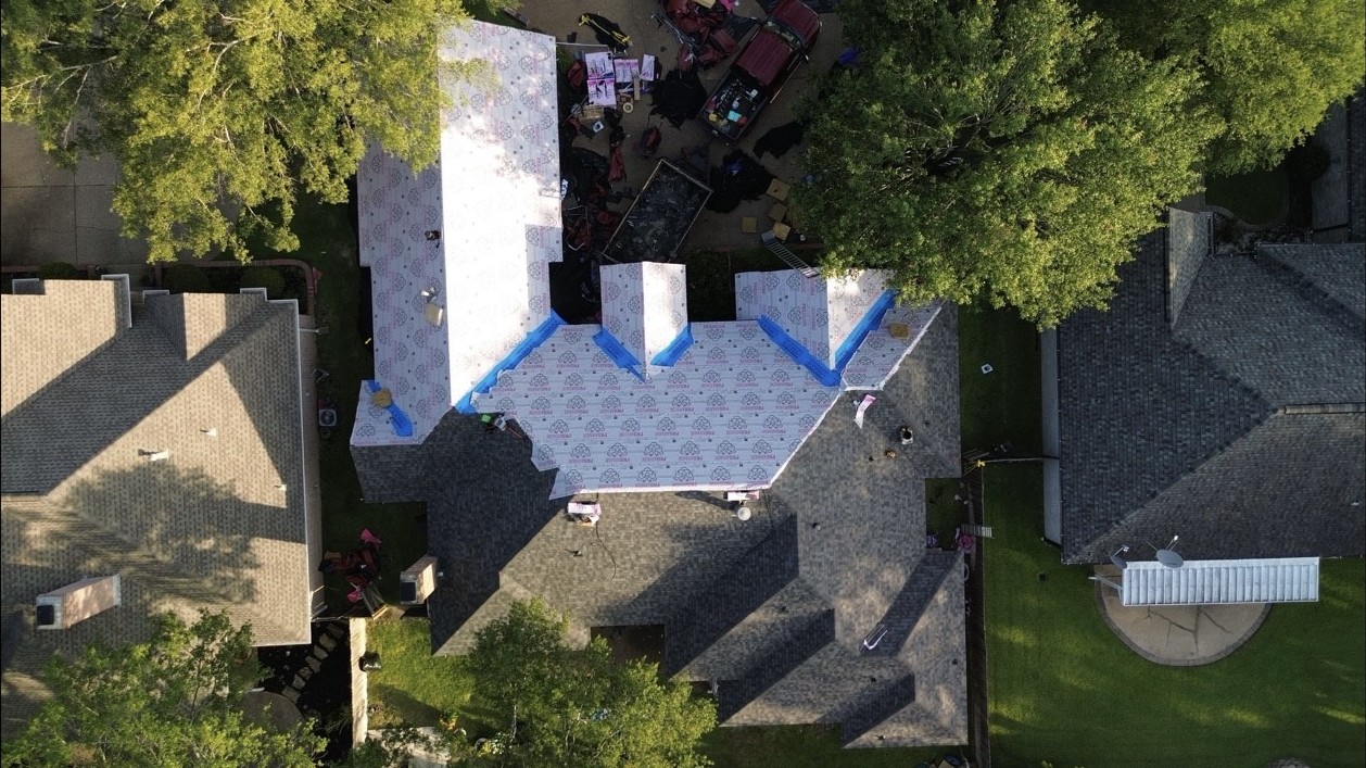 Aerial view of roofing tear-off and underlayment installation